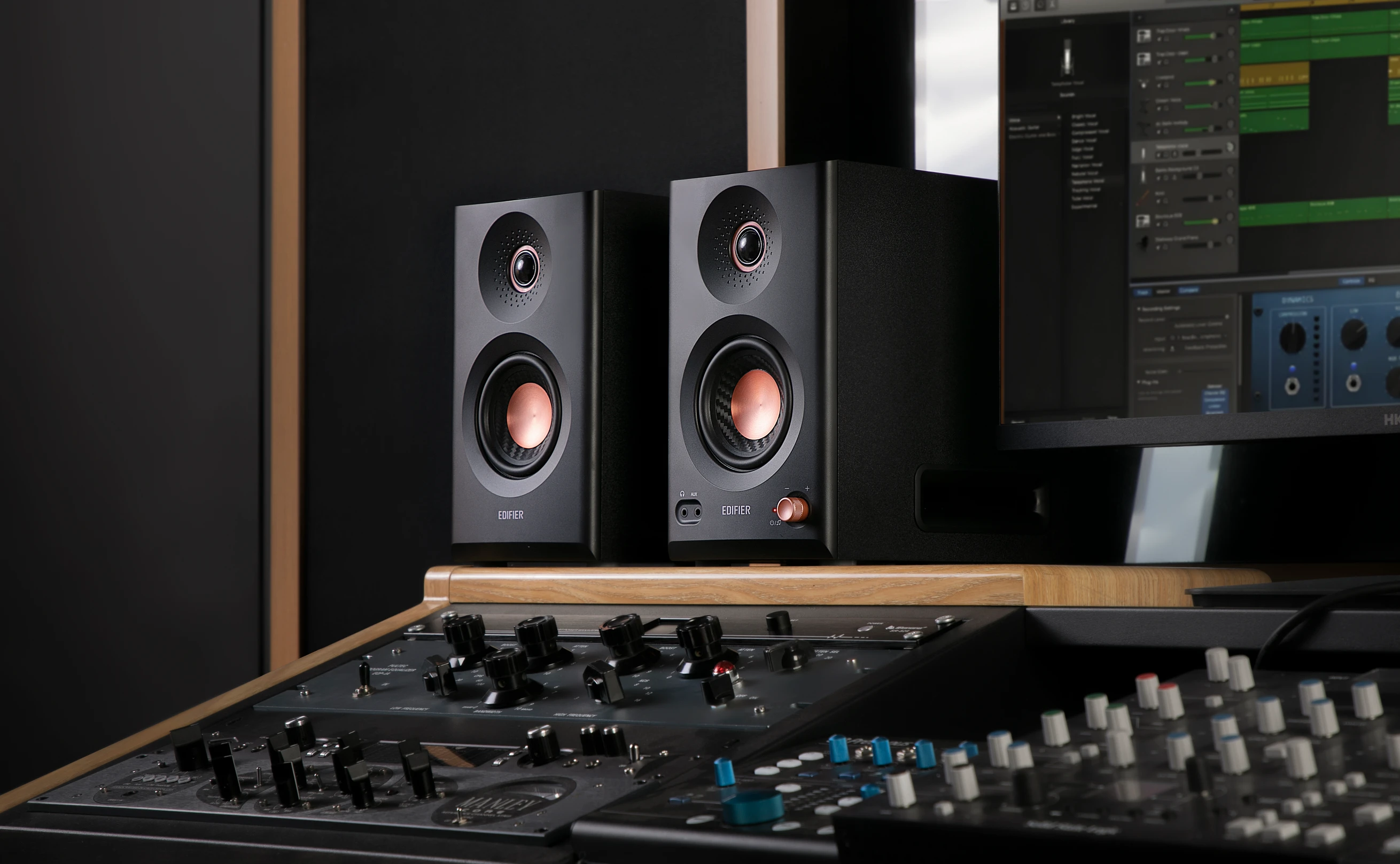 Edifier MR5 studio speakers photographed in a recording studio where they're sitting above the mixing desk