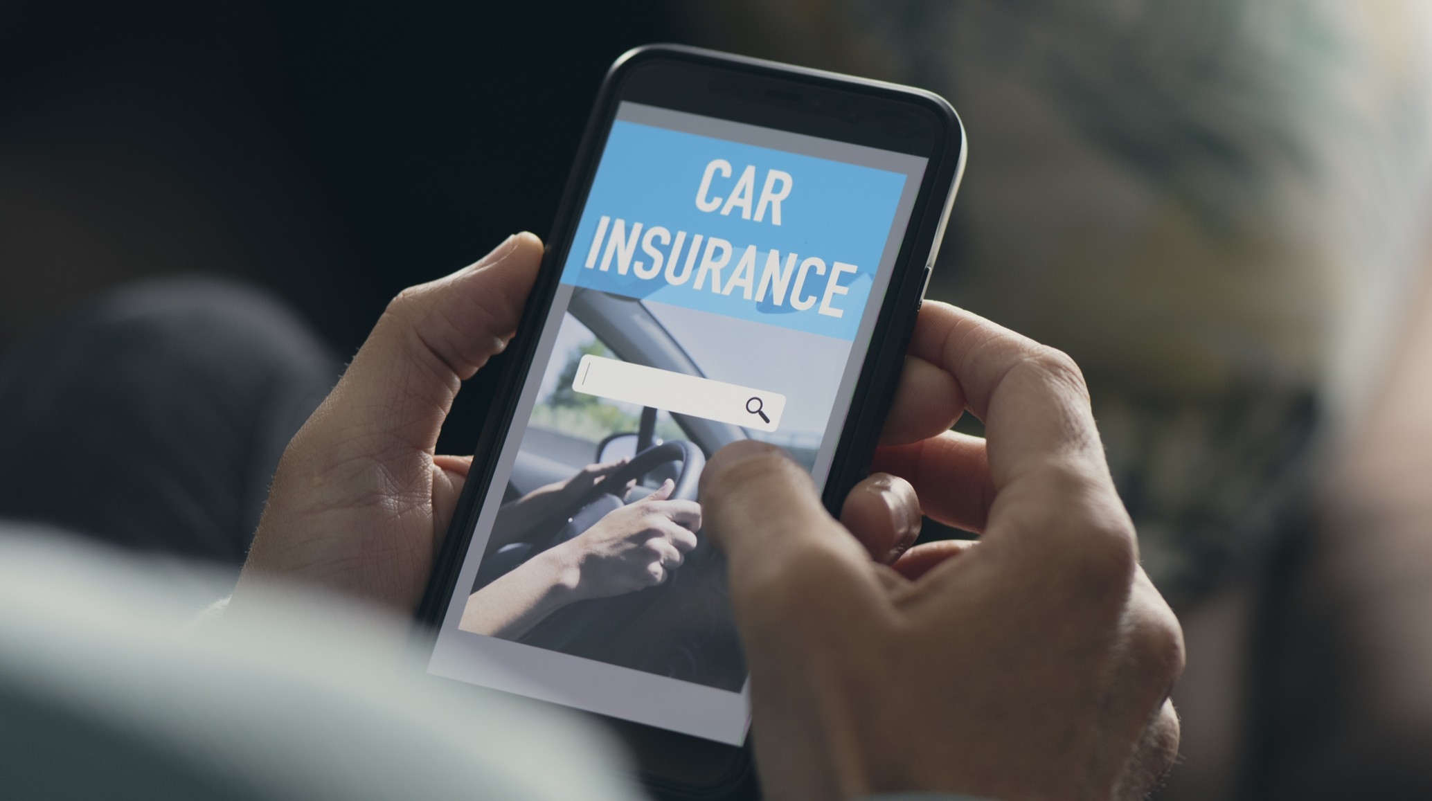 A man searches for car insurance on his smartphone.
