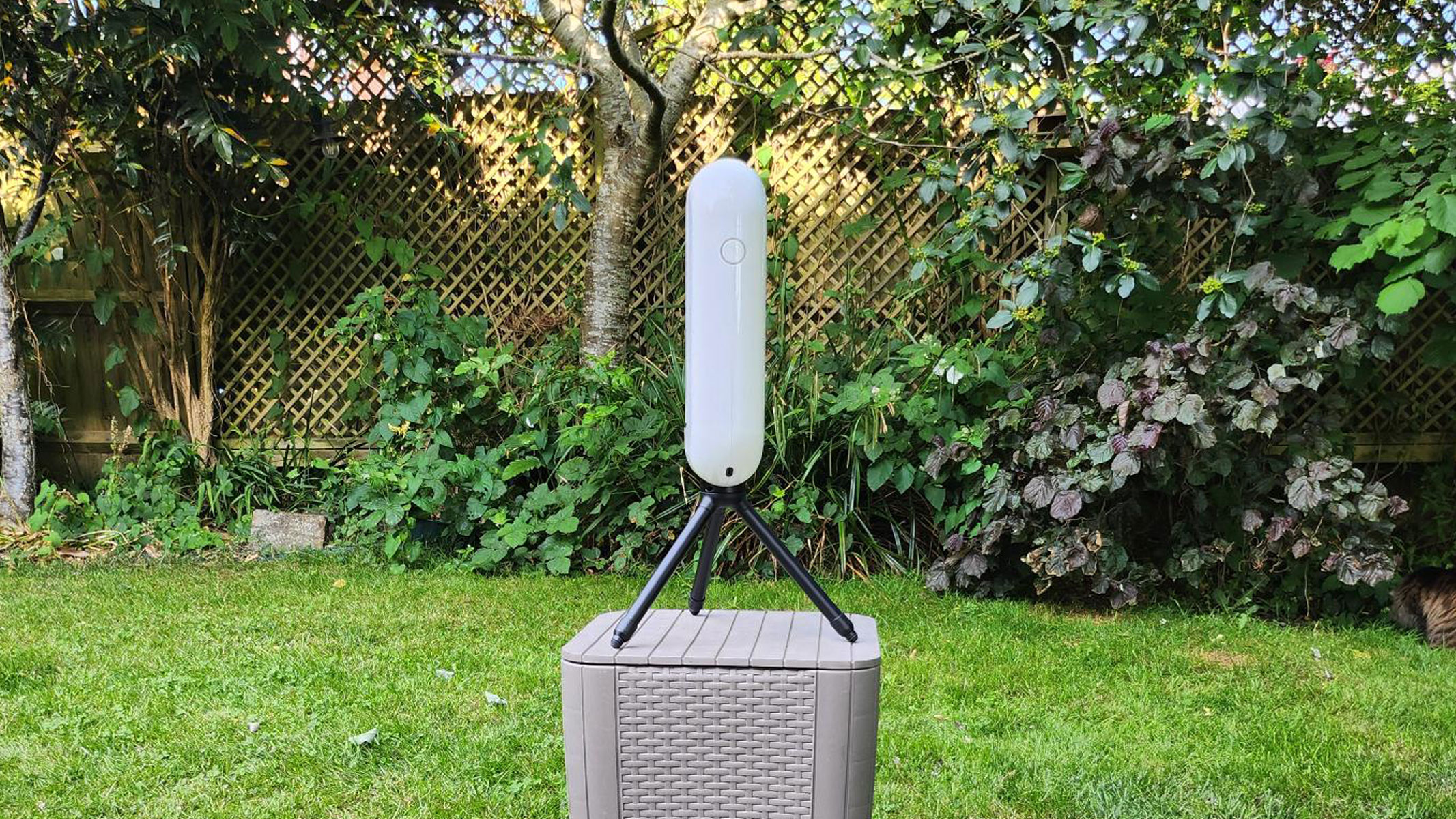 The Vaonis Vespera Pro in neutral position with power button visible with grass and trees in the background.