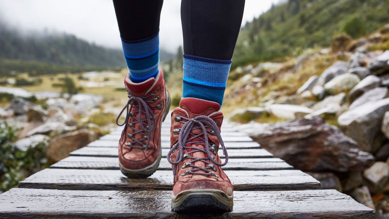 A person walking over a bridge in hiking boots