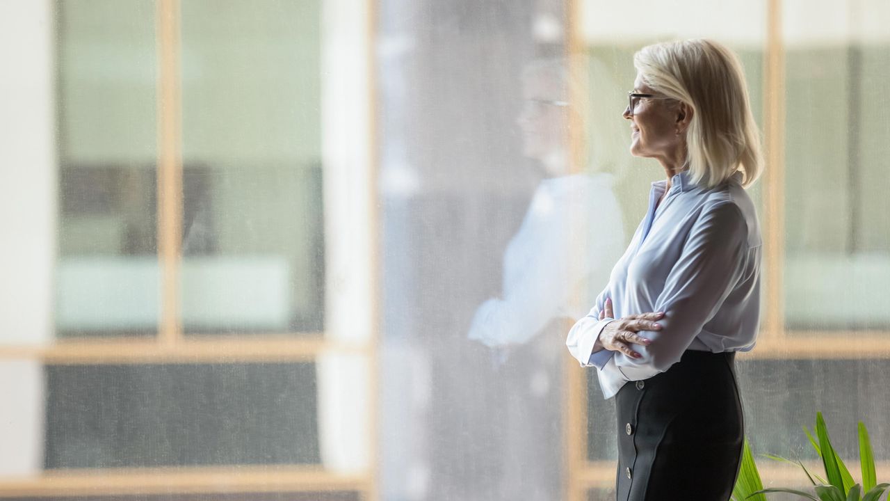 Career woman thinks as she looks out a window