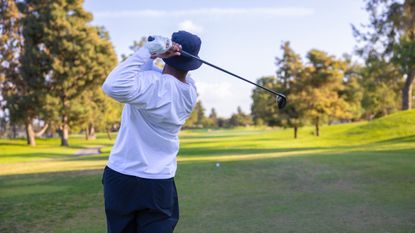 A general view of a male golfer driving the ball