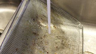 Cleaning the air fryer tray in a sink