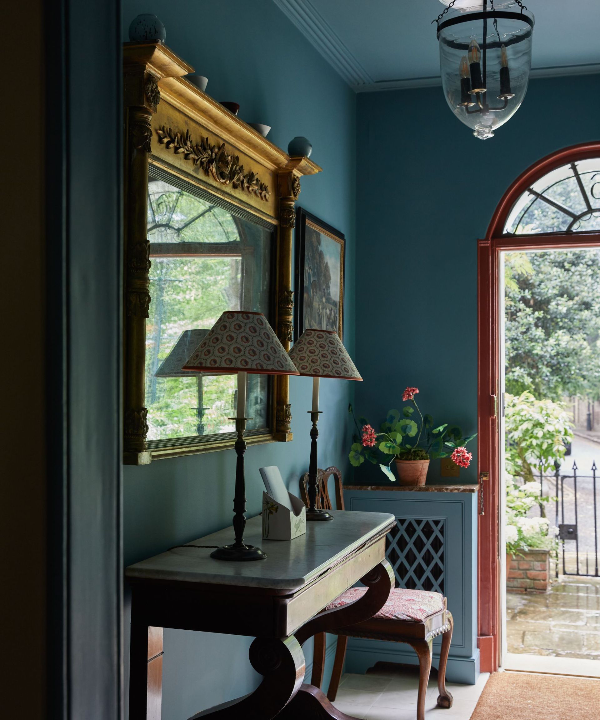 blue entryway in a traditional london home with an unexpected red door