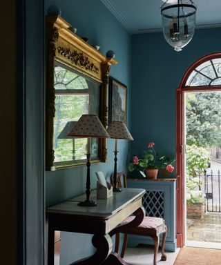 blue entryway in a traditional london home with an unexpected red door