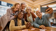 A group of retiree friends pose for a selfie in a diner.