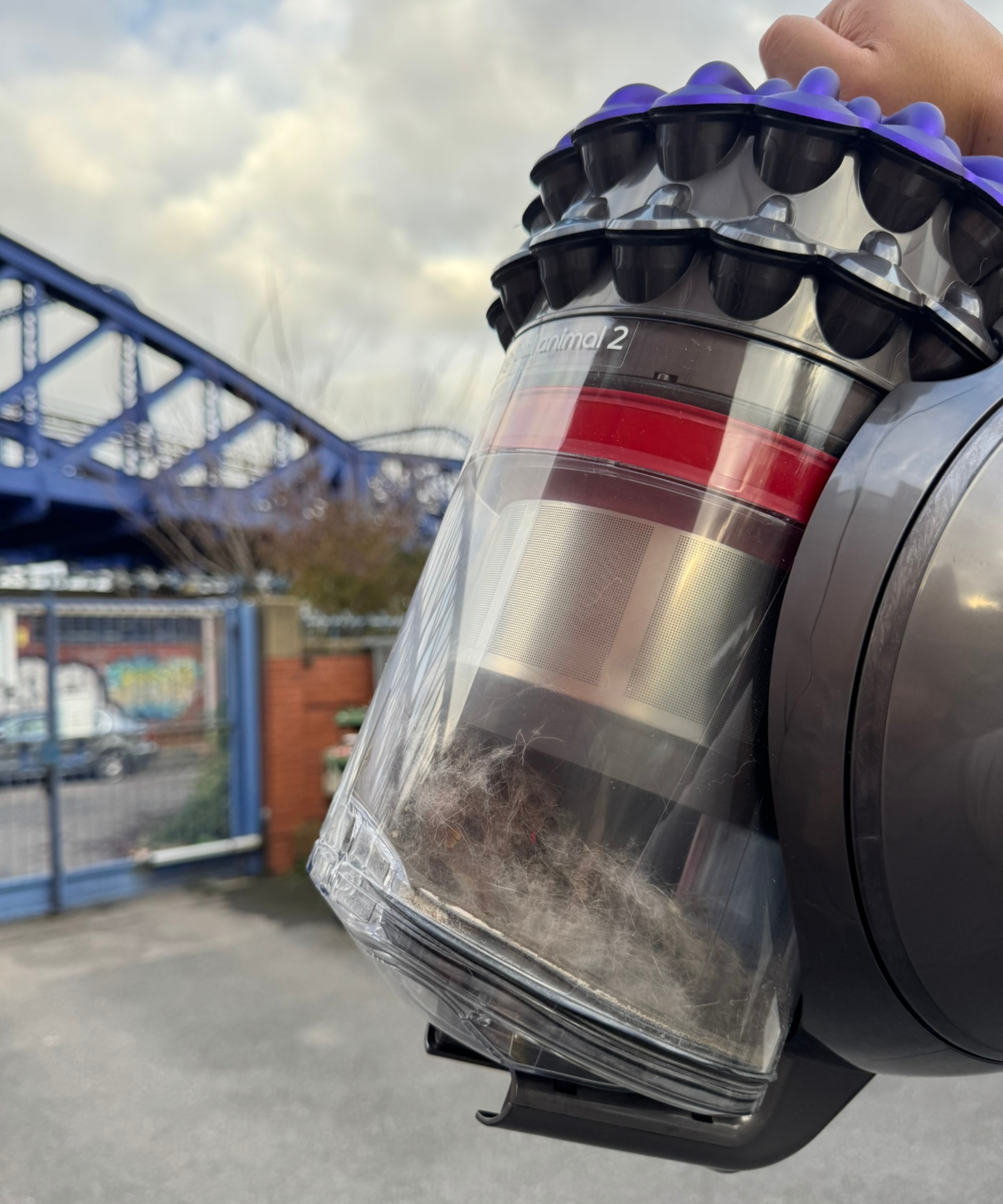 Hand holding the Dyson Big Ball Turbinehead dustbin with visible fur inside, outside Bristol ARC.