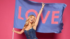 Laura Whitmore holding a giant flag that says 'Love' on it