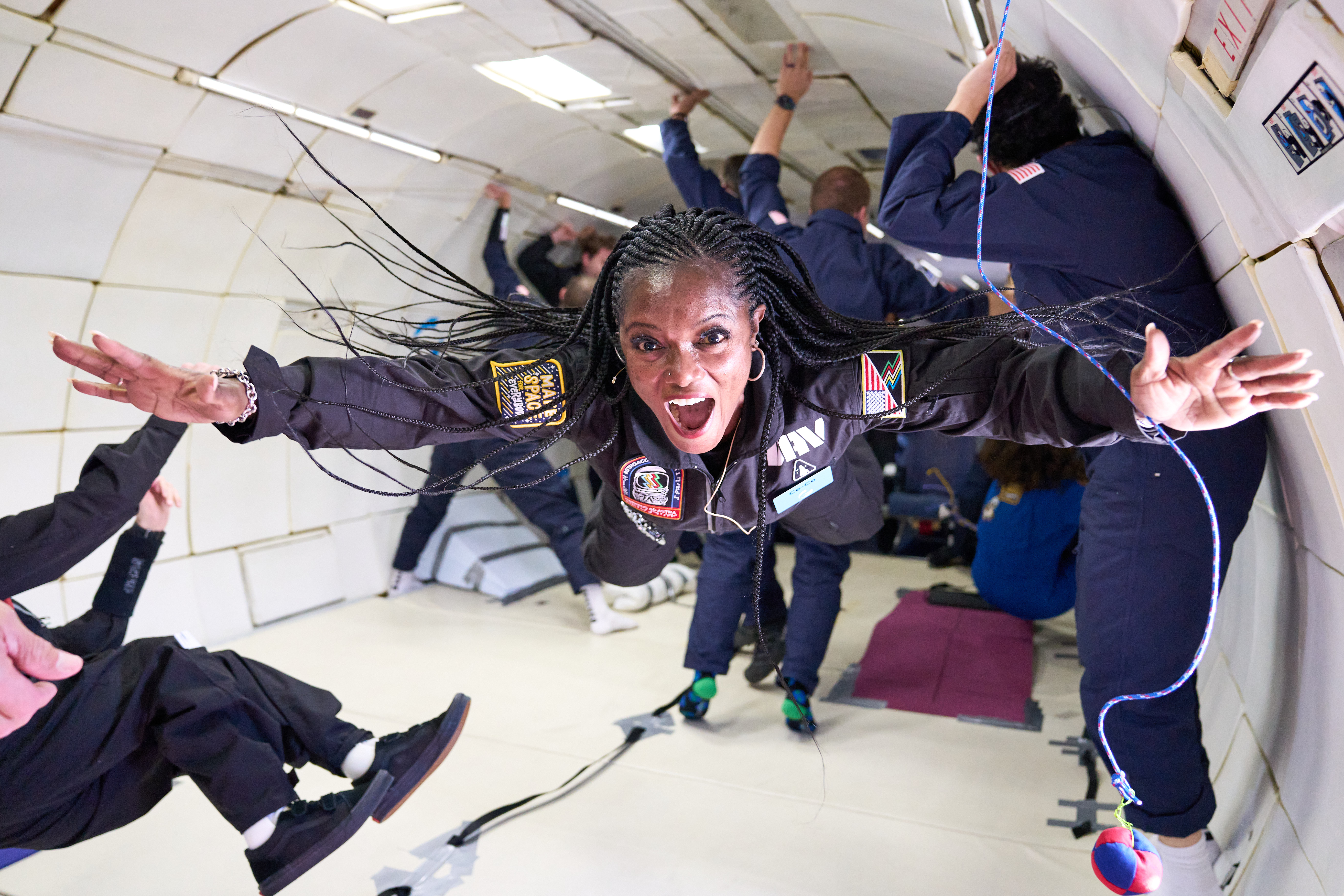 a person in a plane outstretches their arms during a moment of weightlessness induced by a parabola