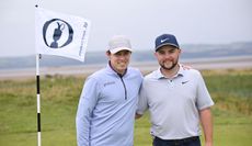 Matt and Alex Fitzpatrick pose next to an Open Championship flag 