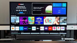 En LG A2 TV står på en TV-bänk och visar appmenyn på skärmen.
