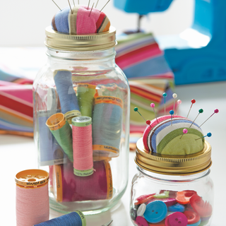 sewing kit with glass jar and thread spools
