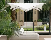 An unusually-shaped contemporary patio umbrella shading sun loungers in a lush garden
