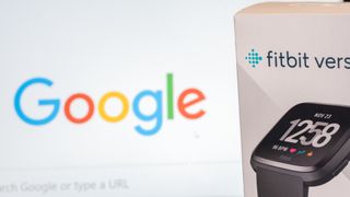 The box packaging of a Fitbit Versa device in front of a screen displaying the Google homepage