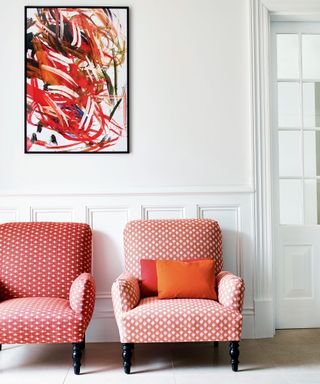 White room with modern art and pink pattern chairs