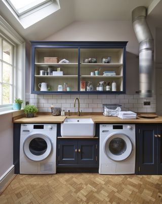 A utility room with two washing machines and a laundry chute.