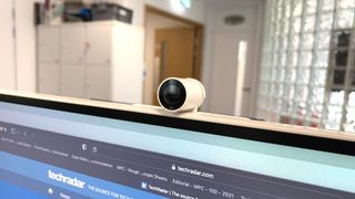 En närbild på en webbkamera monterad på en Samsung M8 Smart Monitor i en kontorsmiljö.