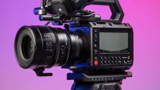 Blackmagic Pyxis 6K camera in the studio, mounted to video tripod, with a vibrant magenta background