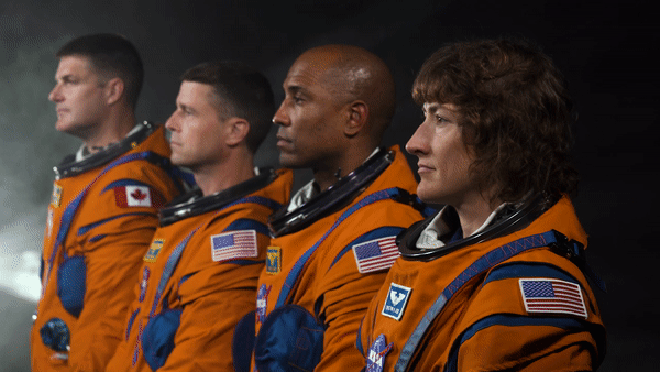 The four astronauts of NASA's Artemis 2 moon mission turn their heads while wearing spacesuits.