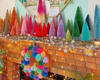 tropical multicolored christmas tree decor on a mantle with pom pomp wreath on the fireplace