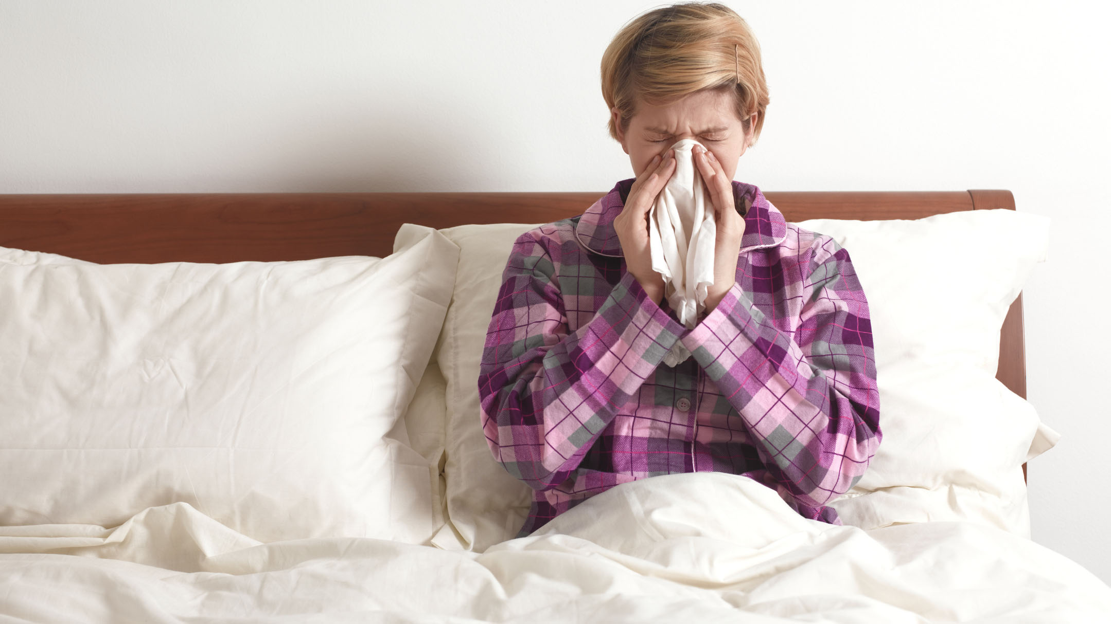 Wanita di tempat tidur dengan flu