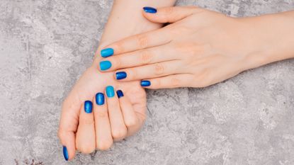 close up of manicured nails with shiny blue polish