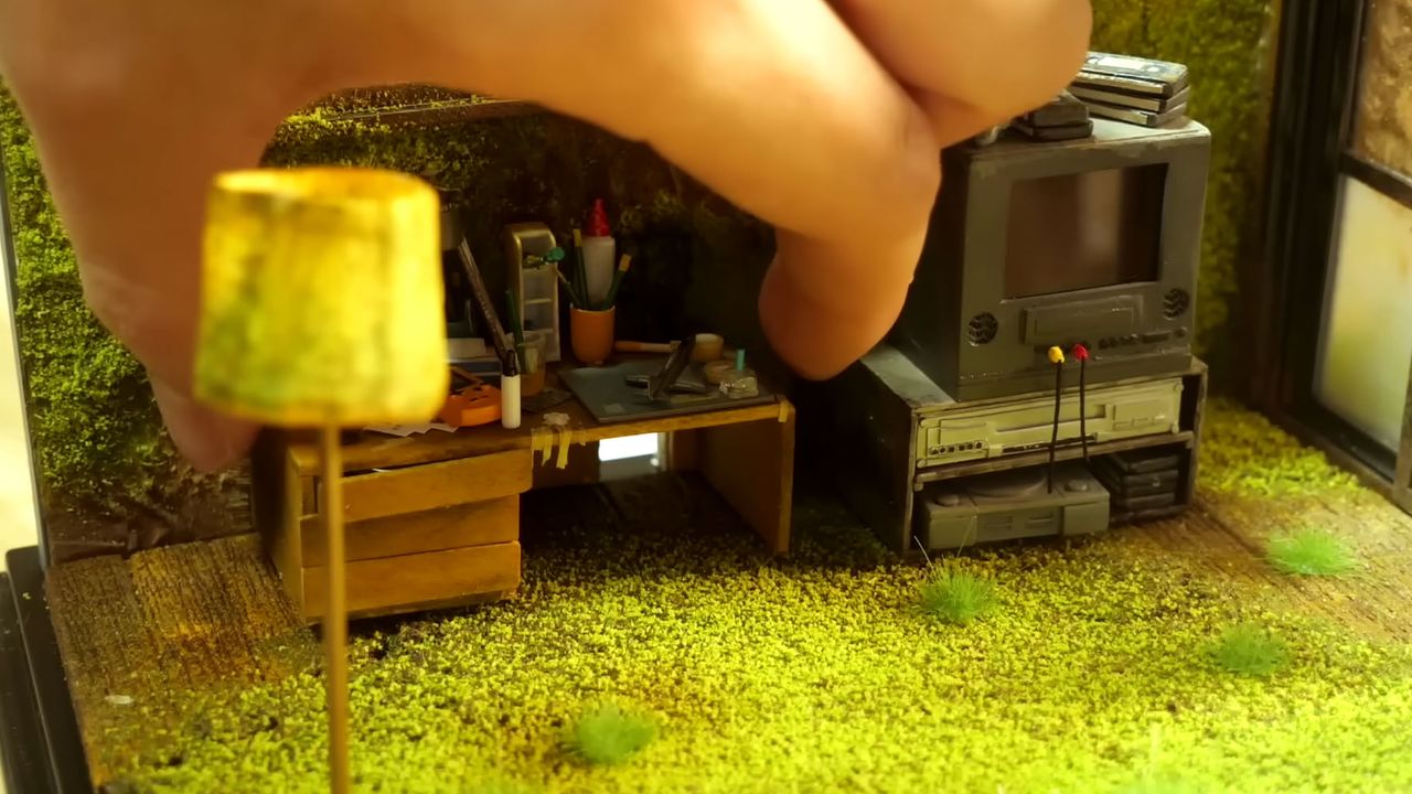 A shot of a hand in a diorama of an overgrown bedroom