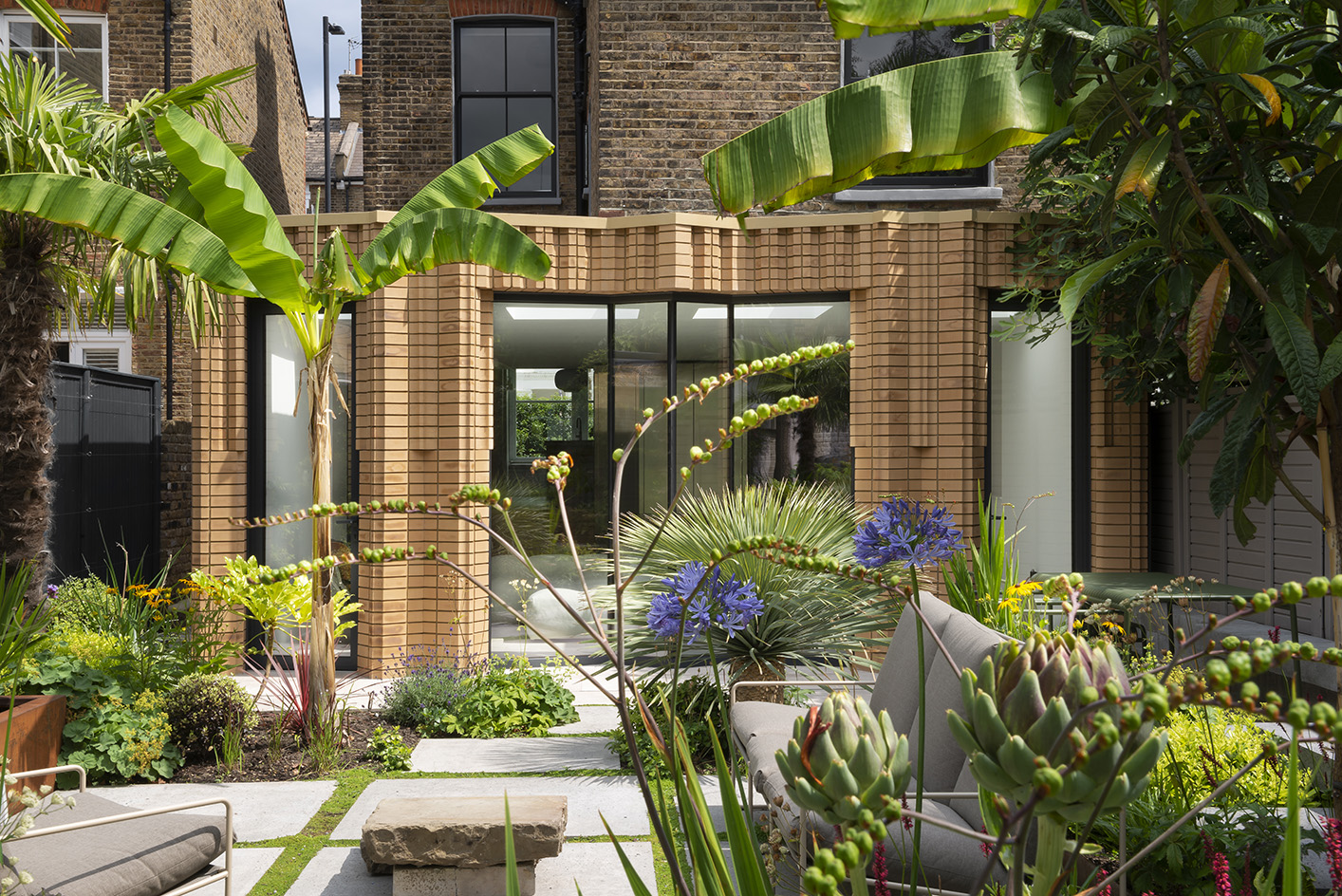 Fulham house, a leafy garden view of brick structure