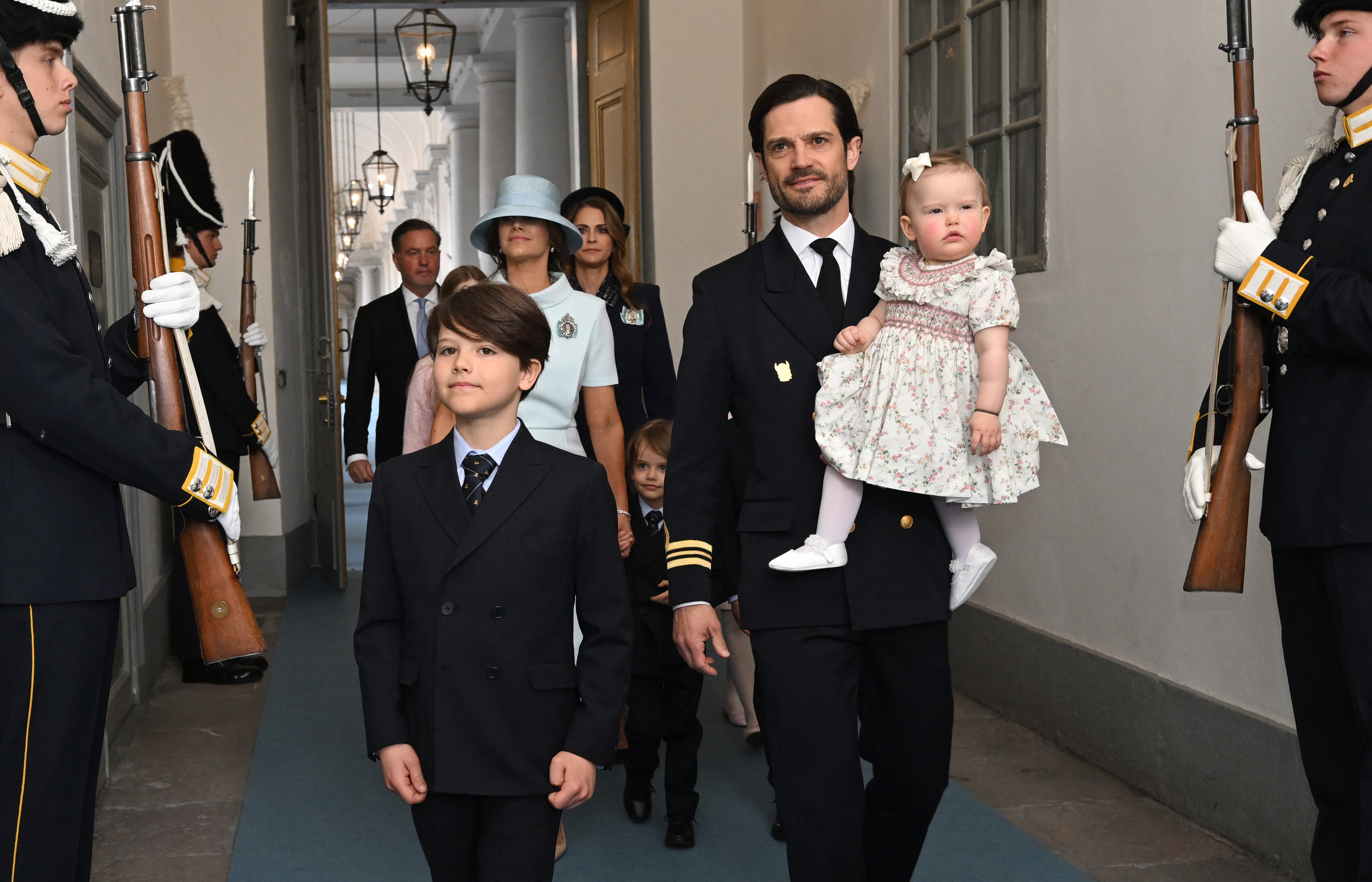Prince Carl Philip holding Princess Ines walking with his sons and Princess Sofia