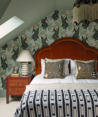 bedroom with patterned bedspread and wallpaper