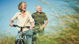 Senior couple riding their bikes in the sunshine