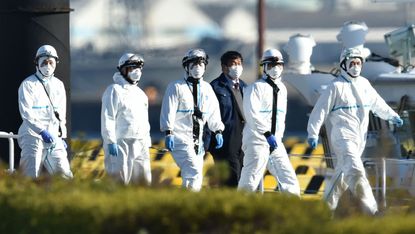 Officials at the Japan Coast Guard base in Yokohama where a cruise ship is in quarantine following an outbreak of coronavirus