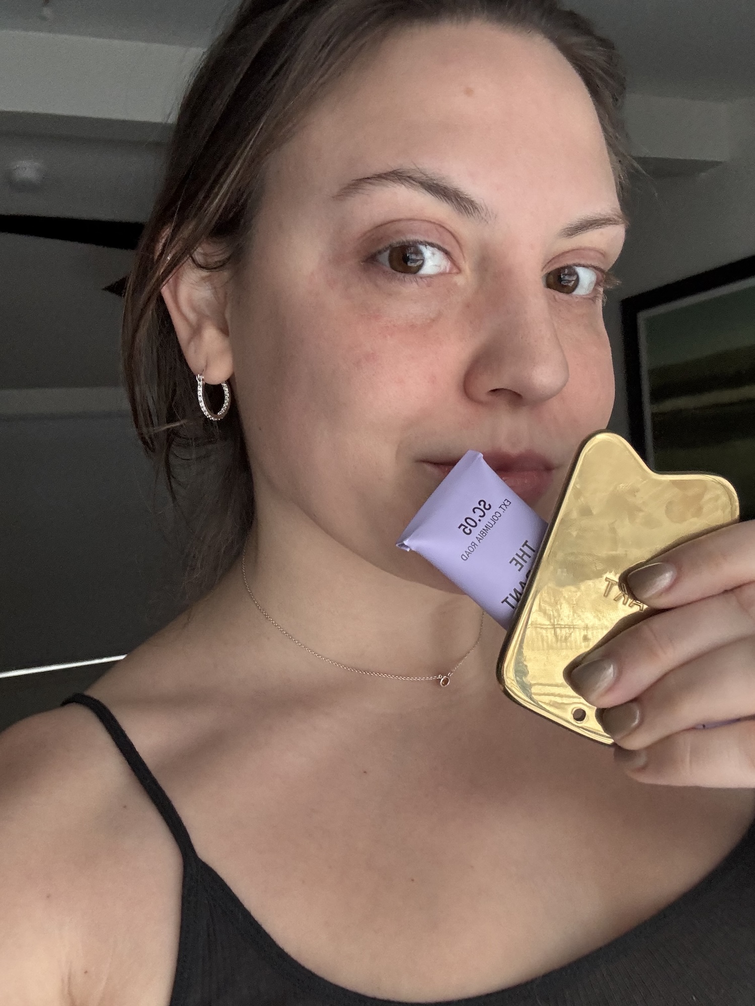 Sophia Vilensky holds AKT's impressive (and luxe) deodorant balm and heavy metal massaging applicator.