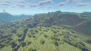An expanse of green fields and mountains in Minecraft