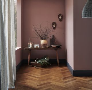 herringbone bamboo flooring in hallway with pink walls