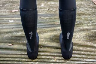 A rider wearing the Spatz Pro Stealth overshoe system on a wooden deck