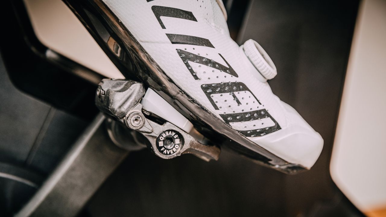 a white specialized clipless road bike shoes, clipped in to a Favero power meter pedal