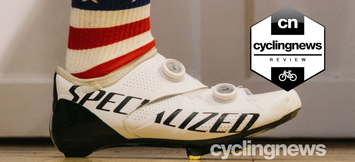 A black and white S-Works Ares shoe, being worn by a cyclist in USA-flag socks