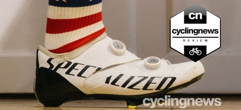 A black and white S-Works Ares shoe, being worn by a cyclist in USA-flag socks