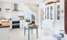 kitchen with white walls tiled flooring and blue wooden table