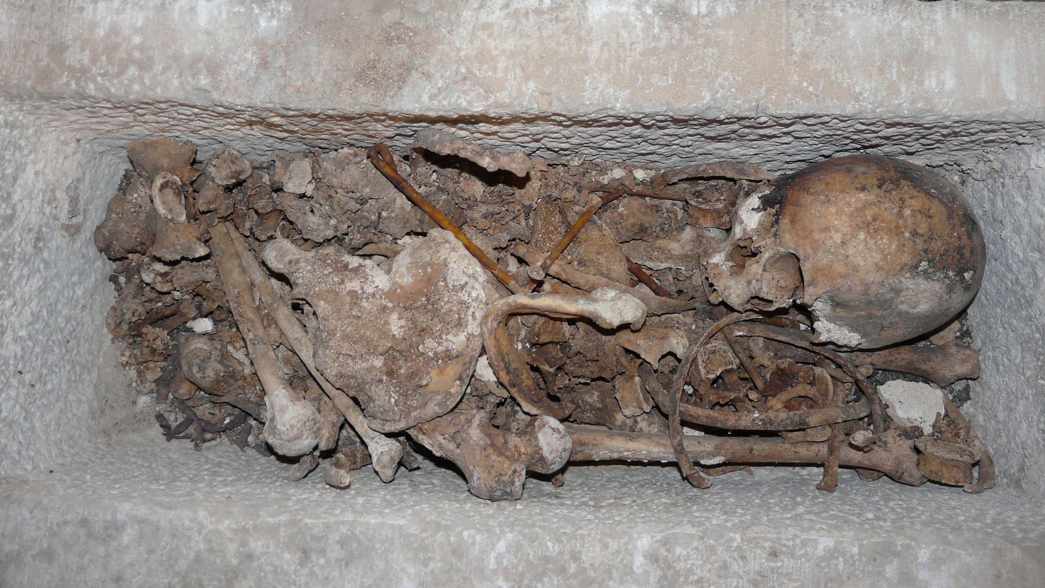 a pile of human bones in a carved stone niche
