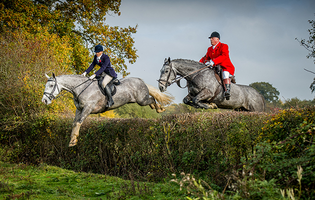 Family affair: Charlotte Bradley and her father Parke Bradley take on a fair hedge at the opening meet of the Crawley and Horsham
