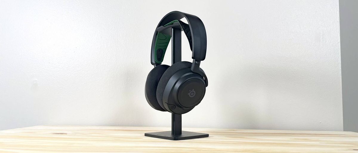 The SteelSeries Arctis Nova 7X on a headphone stand on a wood table