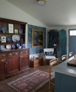 kitchen with dark wood dresser and blue island and rug on floor