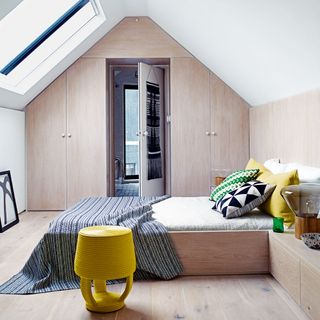 bedroom with wooden bed glass window on roof and cupboard