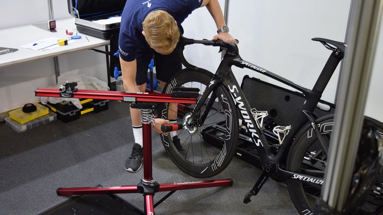 A Quick-Step mechanic uses a power drill to speed up wheel changes on thru-axles