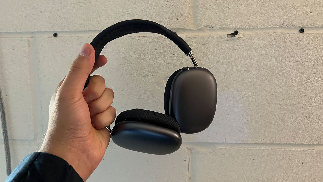 A pair of Apple AirPods Max headphones being held in the hand