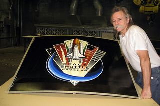 Lockheed Martin graphic artist Jon Irving displays the 'nose art' to be installed on the final space shuttle's external tank. 