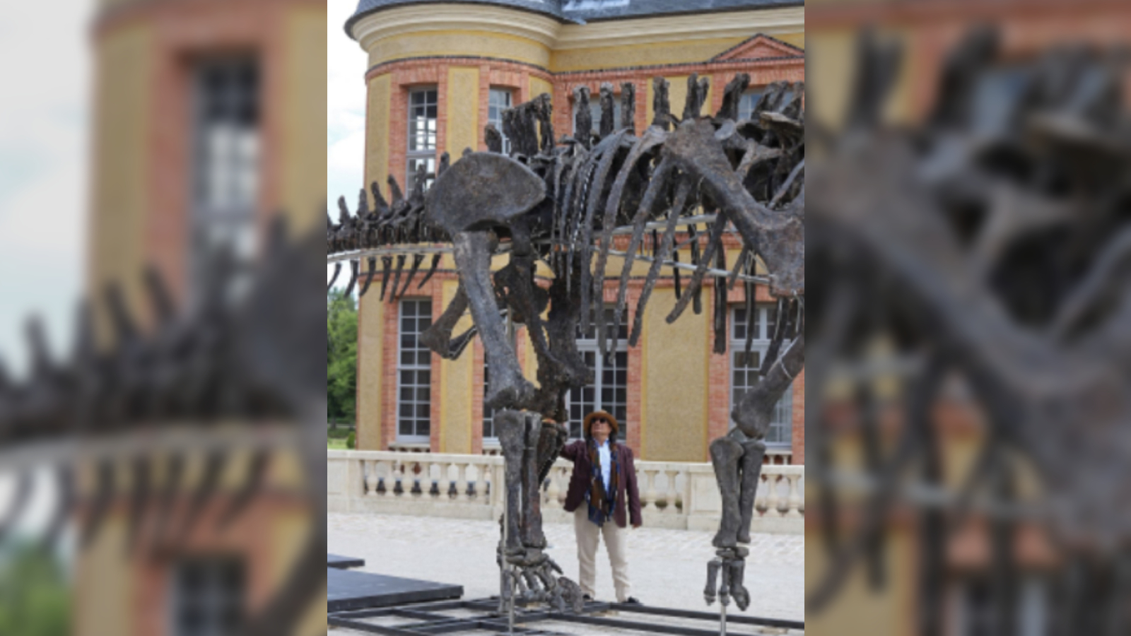 Photo of man stood next to a dinosaur skeleton