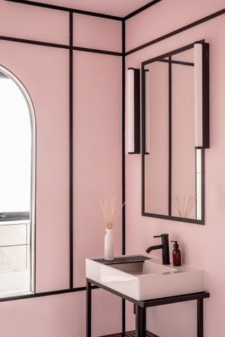 A bathroom in dusty pink with black lines